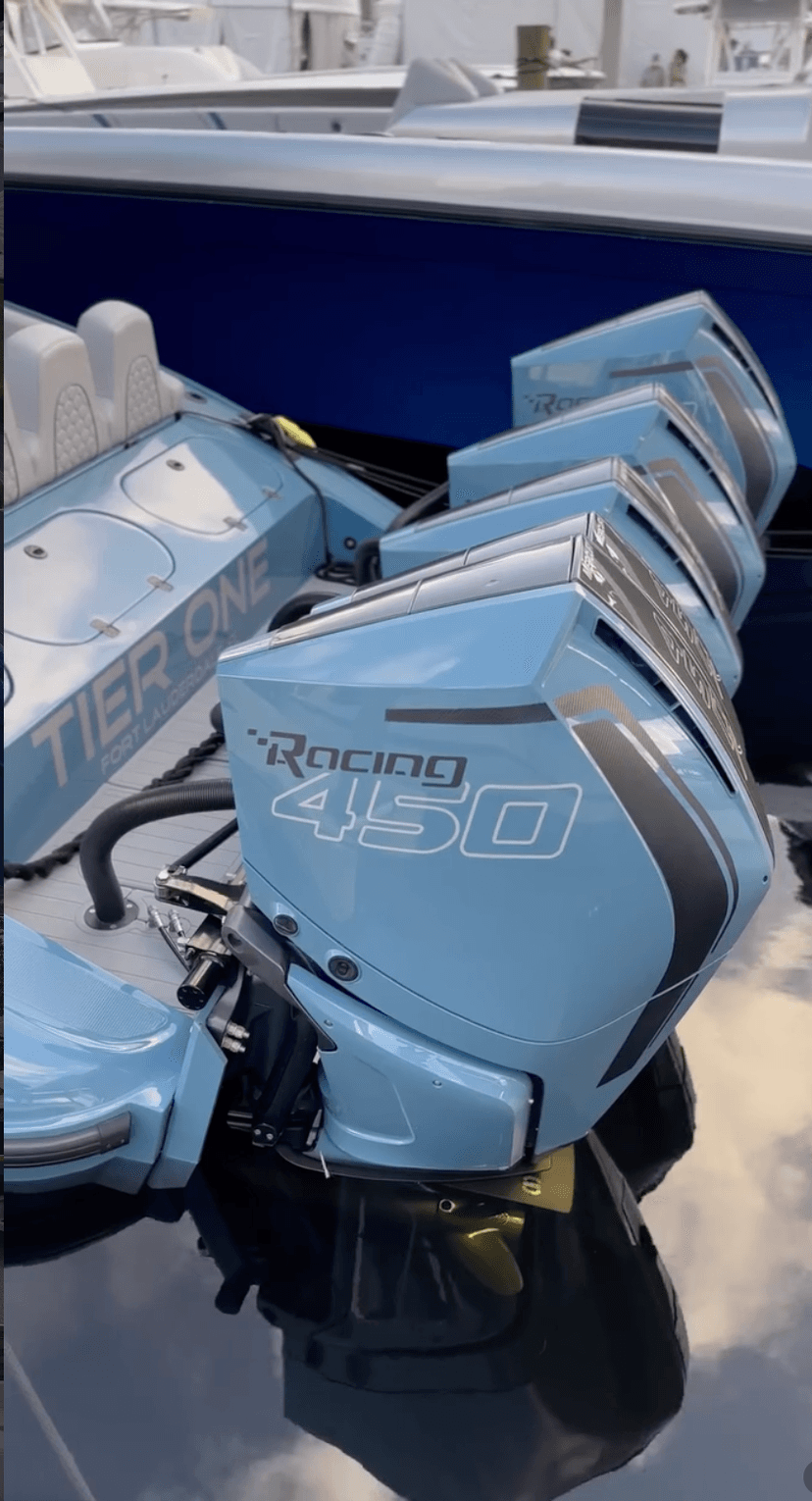 Four Mercury Racing 450 outboard engines mounted on a light blue Tier One boat at a Fort Lauderdale dealer or show display.
